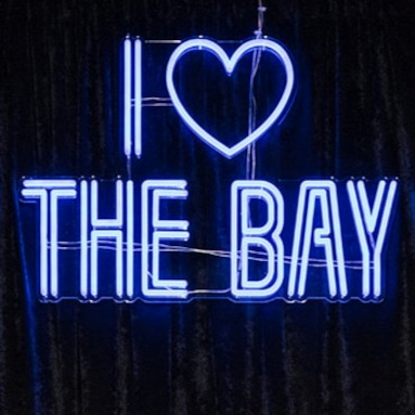 I Love the Bay blue double lined Custom Neon® selfie sign as the backdrop for an event hosted by the San Francisco Foundation