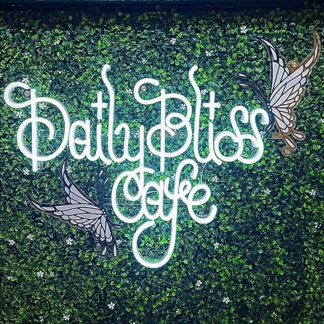 Cafe logo sign by Custom Neon® on a green wall @dailyblisscafe