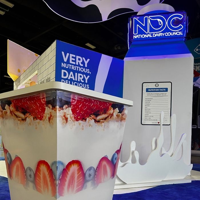 Close-up of the National Dairy Council Custom Neon® sign beside a branded yogurt cup display