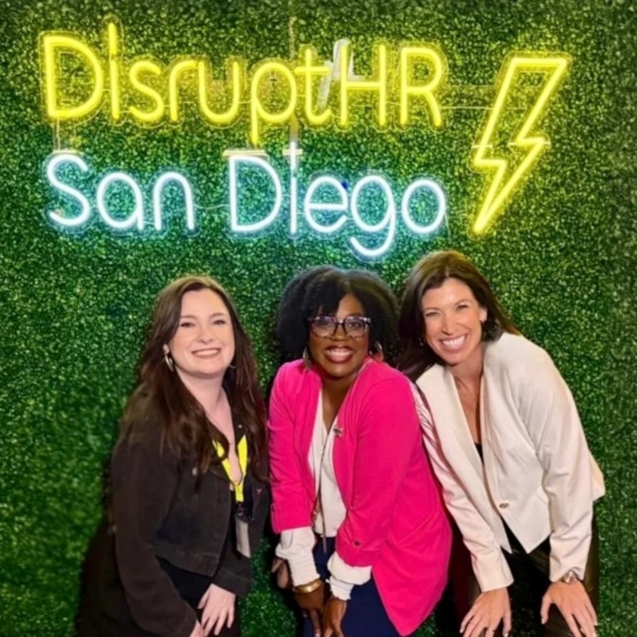 Yellow and white Custom Neon® Disrupt HR San Diego event sign on a grasswall
