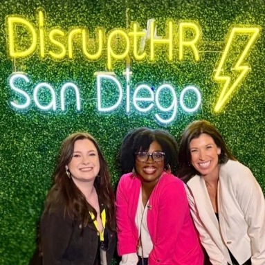 Yellow and white Custom Neon® Disrupt HR San Diego event sign on a grasswall