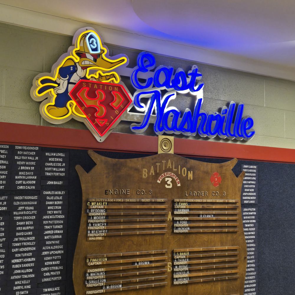 East Nashville Fire Department logo in yellow red and blue LED neon with UV printed silver acrylic backboard shown in a dark room