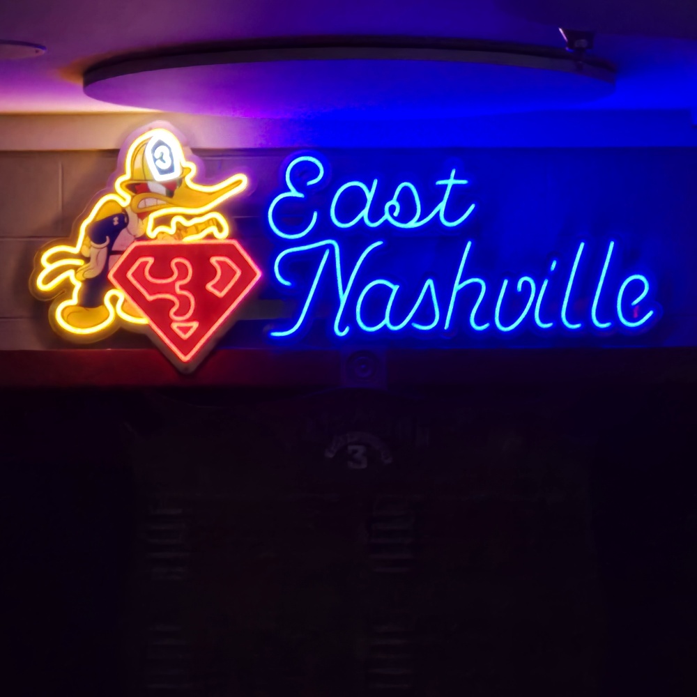 East Nashville Fire Department logo in yellow red and blue LED neon with UV printed silver acrylic backboard shown in a lighted room