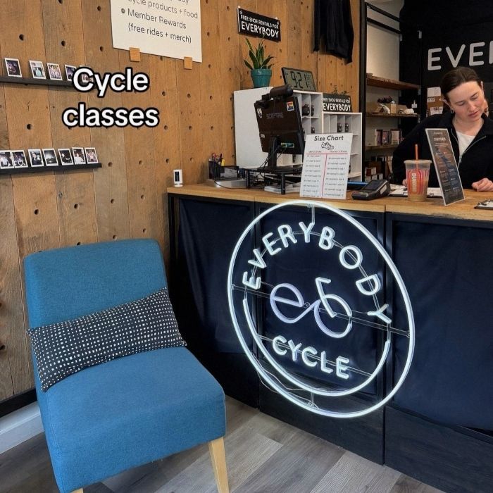 White logo sign by Custom Neon® for reception @everybodycycle