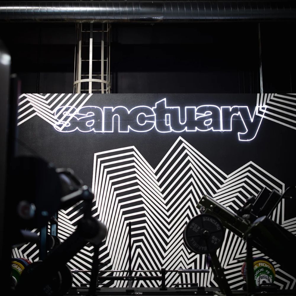 Large white Sanctuary sign in double lined LED neon flex on a black and white backdrop @fallensanctuarygym