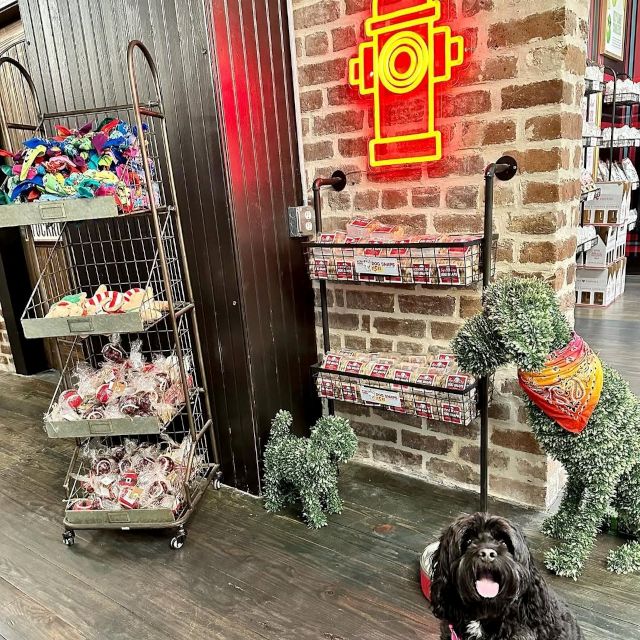 Red fire hydrant made by Custom Neon® on a brick wall in a @byrdcookieco store