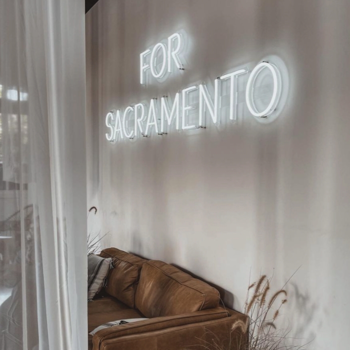 Large white Custom Neon® sign reading For Sacramento on a white wall @projectchurchsac