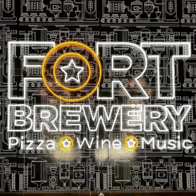 Fort Brewery Pizza Wine Music custom white and yellow LED neon sign on an illustrated brewery mural wall