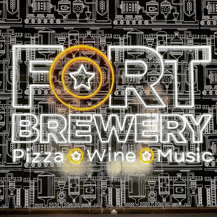 Fort Brewery Pizza Wine Music custom white and yellow LED neon sign on an illustrated brewery mural wall