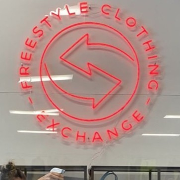 Freestyle Clothing Exchange red circular Custom Neon® logo sign on a white wall @freestyleclothingexchange