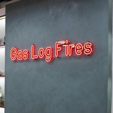 Red Custom Neon® retail sign in NeonGlow font on the showroom wall @pivotstove