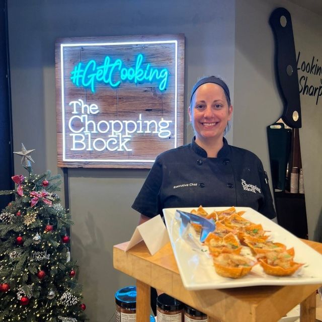 GetCooking Custom Neon® sign for The Chopping Block above a chef holding a food tray