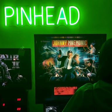 Green Custom Neon® PINHEAD sign above pinball machines @pinheadaustralia 