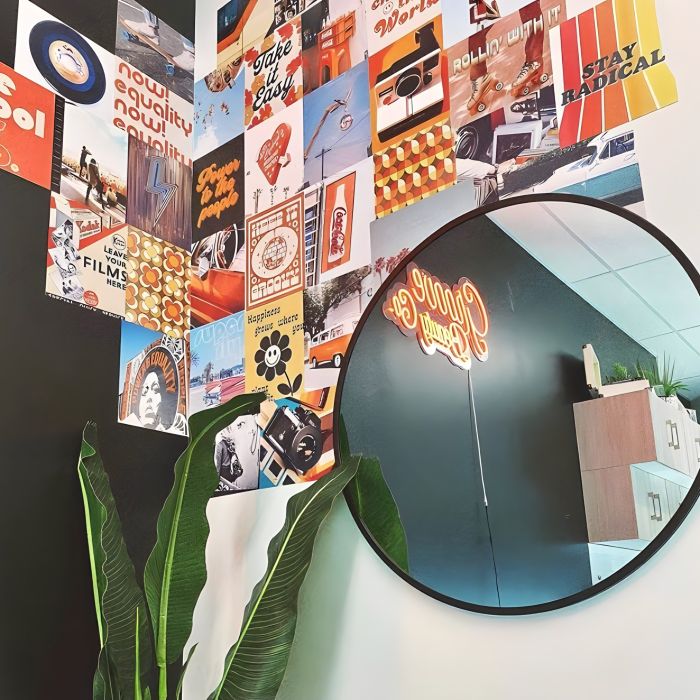 Orange Custom Neon® Groove Beauty Co logo sign reflected in a mirror in the @groovebeautyco hair salon