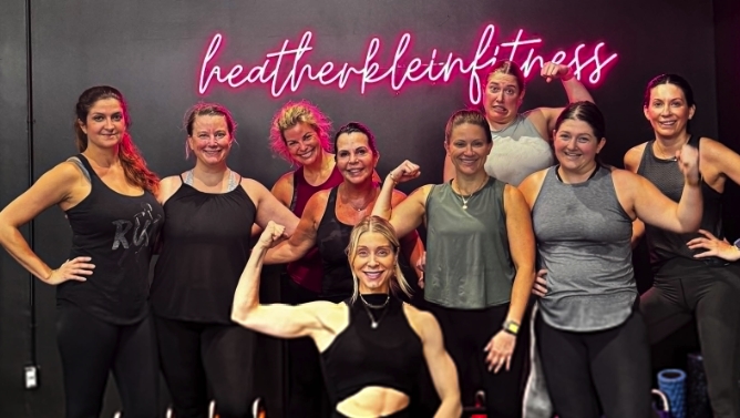 Rgb color changing Custom Neon® gym sign mounted on a black wall @heatherklein_fitness