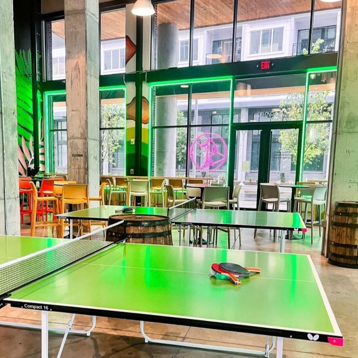 Hi-Wire Brewing Nashville taphouse with a pink logo in the window made by Custom Neon® shown from inside the venue @hiwirebrewing_nash