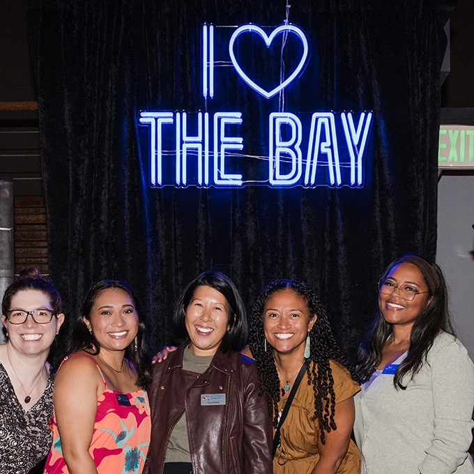 I Love the Bay blue double lined Custom Neon® selfie sign as the backdrop for an event hosted by the San Francisco Foundation