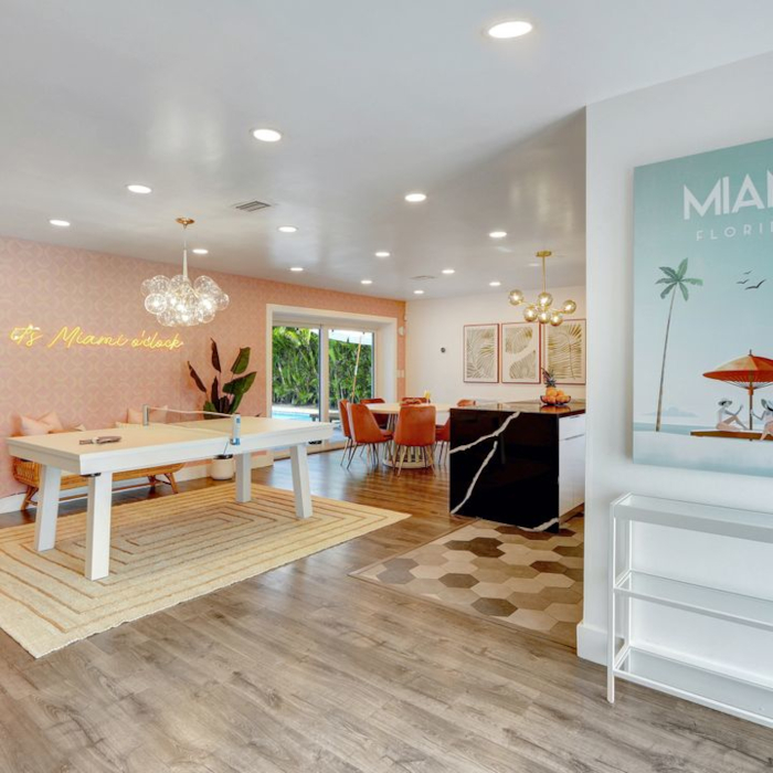 Let the Games Begin large dark yellow on a dark wall Custom Neon® sign in the games room of an Airbnb home designed by Somerled