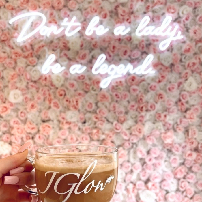 White Custom Neon® selfie sign on rose wall reading Don't be a lady be a legend @jglowbeautyllc