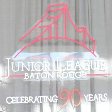 Custom Neon® Junior League Baton Rouge, Celebrating 90 Years sign on a white curtain backdrop
