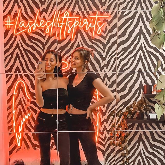 Custom Neon® hashtag lash salon backdrop sign on a mirrored Instagram wall @reallashclub