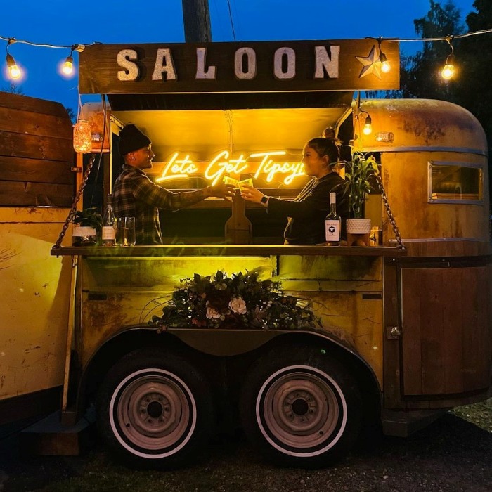 Let's get tipsy yellow Custom Neon® quote sign in a mobile bar trailer @thetipsytire