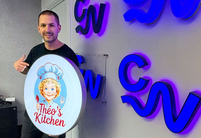 Round front lit sign held by Jake Munday from Custom Neon