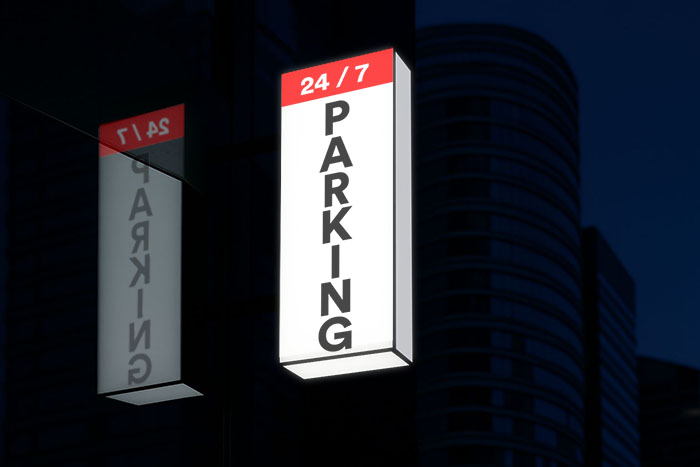 Fully illuminated wayfinding light box sign on the exterior of an undercover parking garage