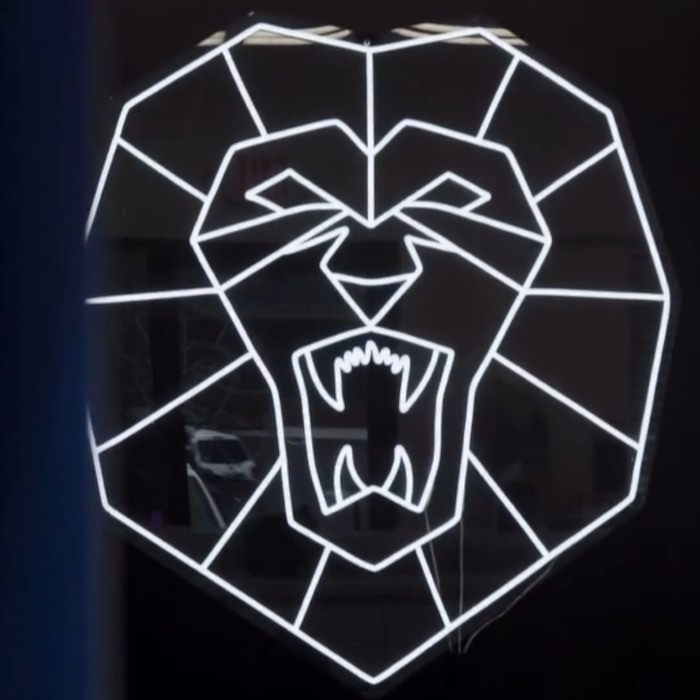 White geometric lion head LED neon sign in the window of Lion Chaser Fitness in Atlanta