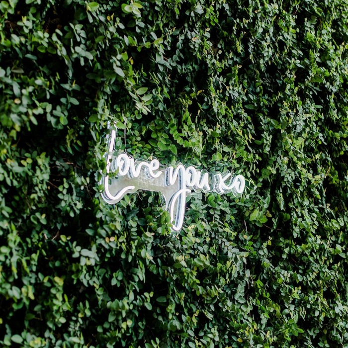 Custom Neon® white LED Love You XO sign on a large greenwall @candileonardphotography