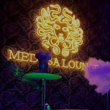 Medusa Lounge logo in dark yellow LED neon mounted on a dark wall - made by Custom Neon®