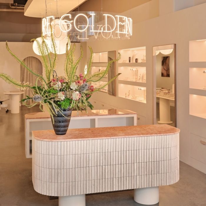 Ring-shaped warm white Forever Golden LED neon sign suspended above the counter in a Dallas jewelry boutique