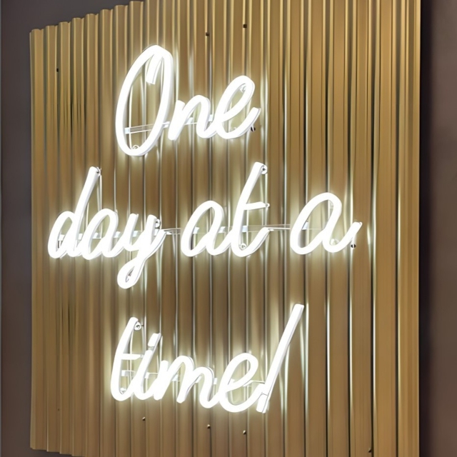 White Custom Neon® word sign on goldmetal backdrop @manonprinceinteriors