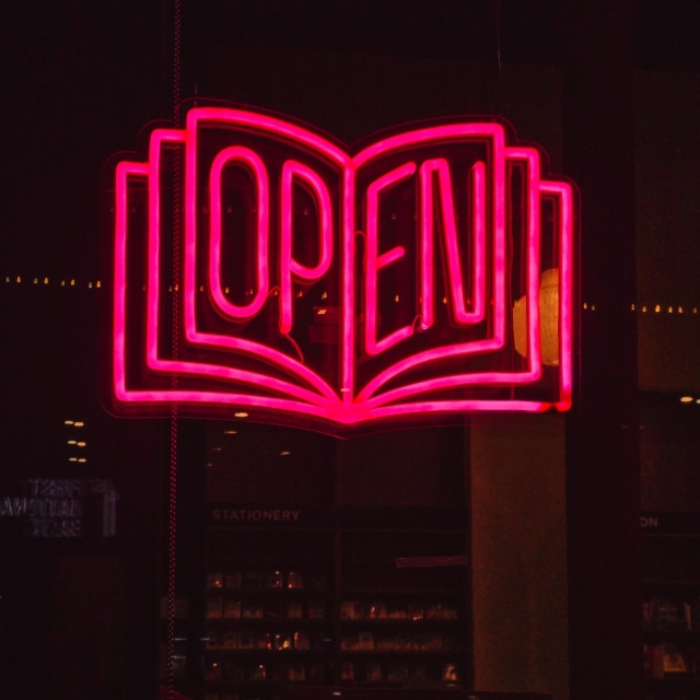 Custom Neon® pink book shaped open sign in the window @readinginpublicbooks