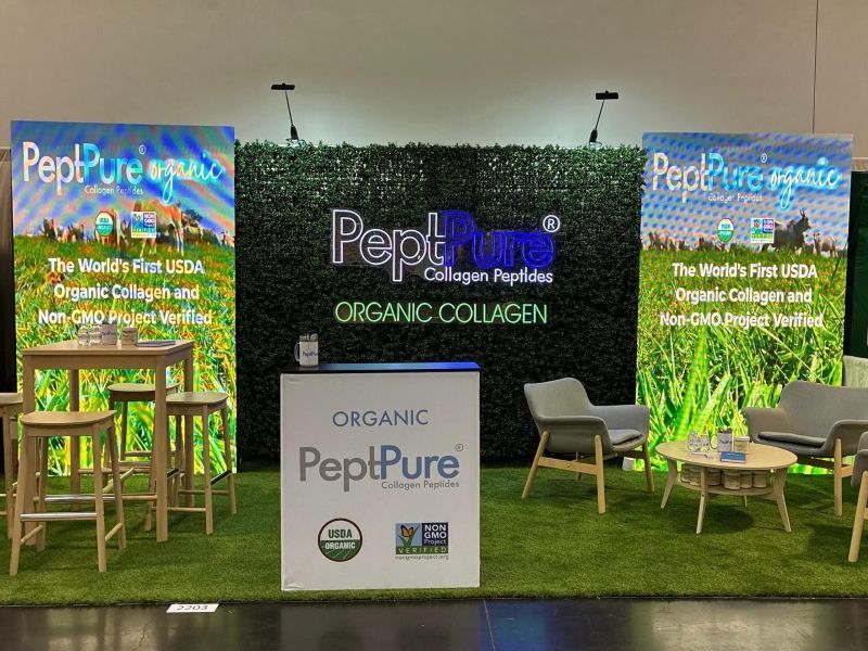 PeptPure Custom Neon® sign centered in a trade show booth flanked by Organic Collagen banner displays