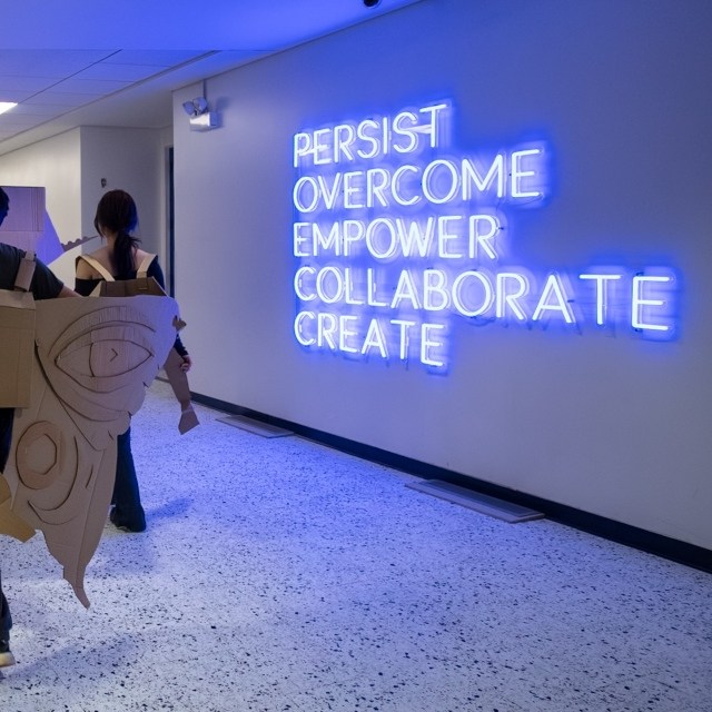 Persist Overcome Empower Collaborate Create Custom Neon® sign in a Northeastern Illinois University hallwa