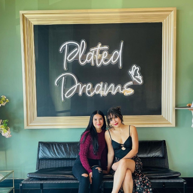 Custom Neon® logo selfie sign on a black wall @plateddreamscafe