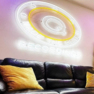 White and Yellow Custom Neon® logo sign in a recording studio @qmadethebeat