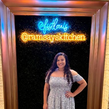 Custom Neon® blue and orange sign in a framed selfie station reading @fsstlouis @ramsaykitchen