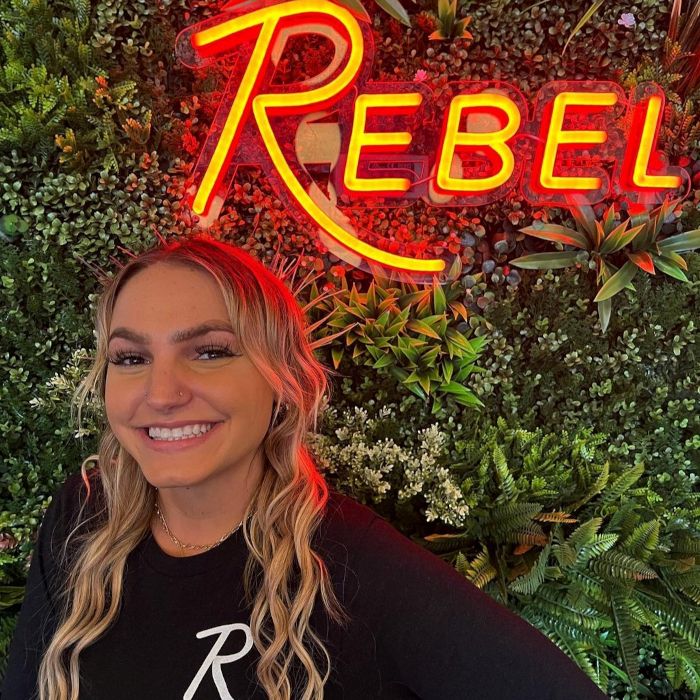 REBEL red Custom Neon® restaurant name sign shown above a staff member @rebelkitchenbar 