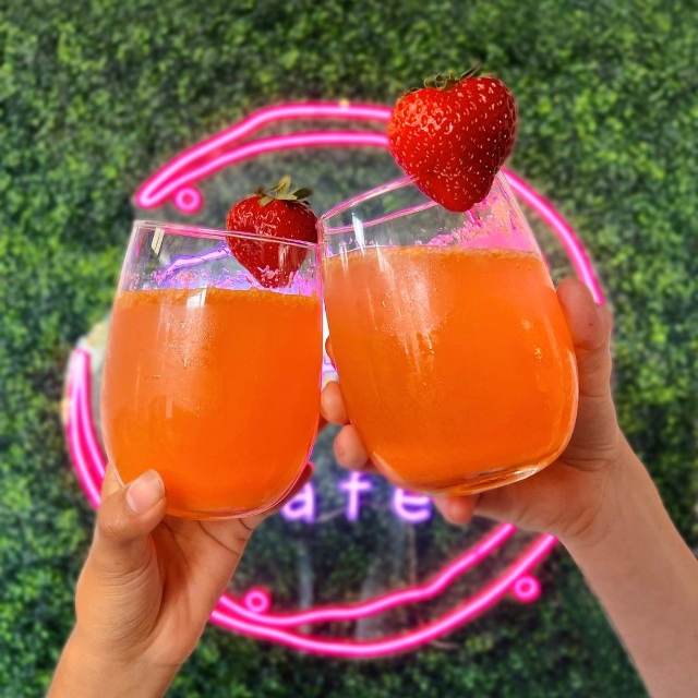 Custom Neon® cafe logo sign on a green wall @rose_cafe_fl