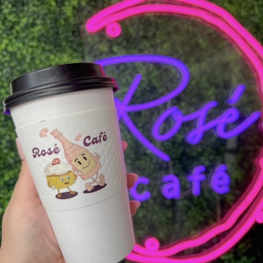 Custom Neon® cafe logo sign on a green wall @rose_cafe_fl