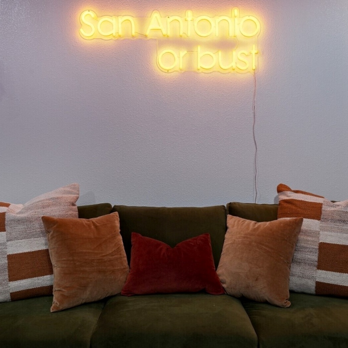 San Antonio or Bust orange LED Custom Neon® sign in a living room wall @hometeamvacationrentals