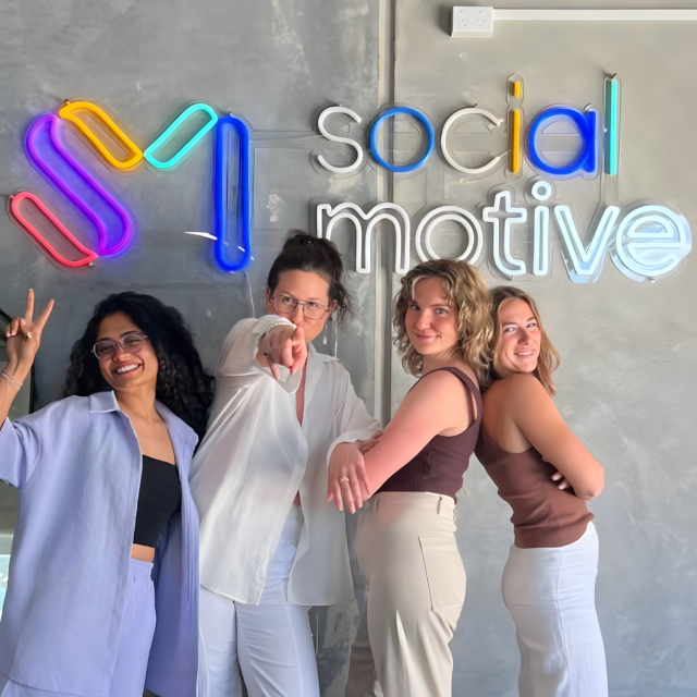 Colourful Custom Neon® office logo sign on a grey concrete wall @socialmotive