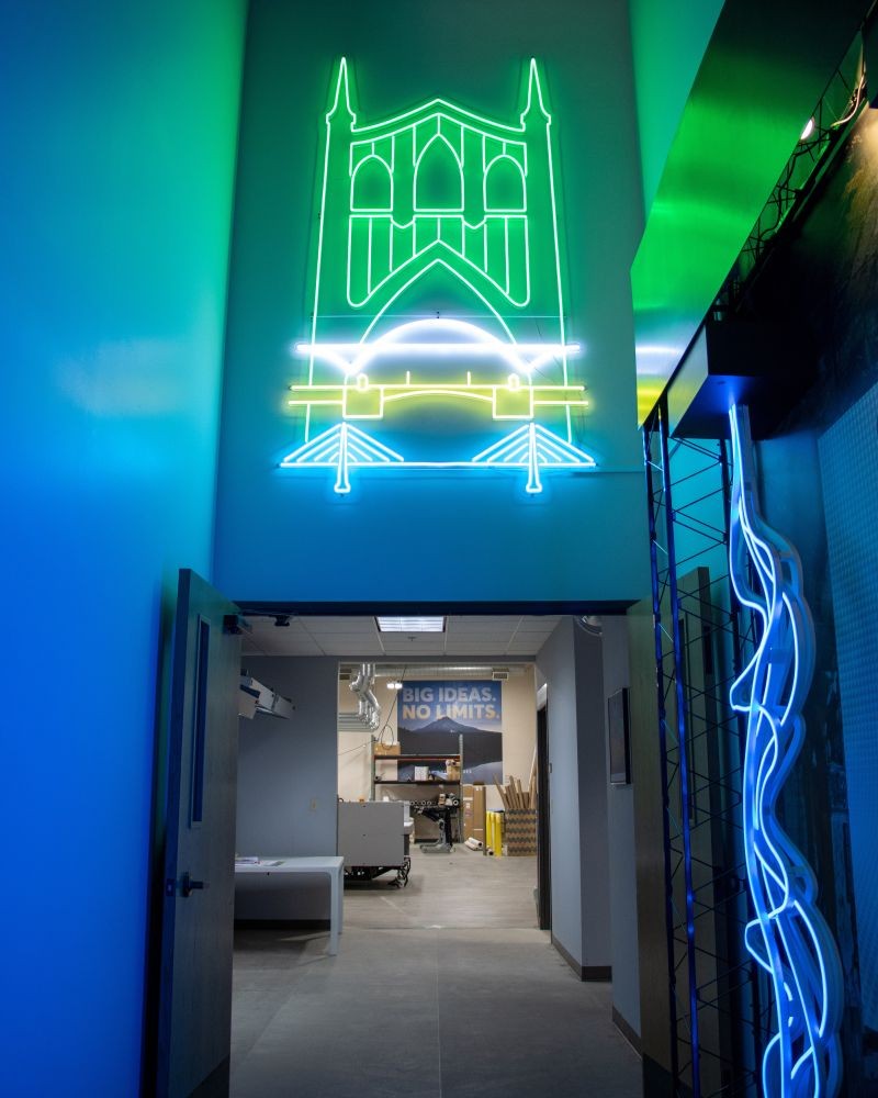 Custom Neon artwork of St Johns Bridge with blue LED neon rope simulating water at the entrance to the Infinity Images workspace