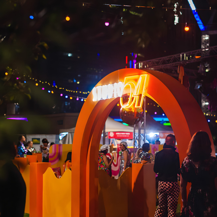 Weatherproof Custom Neon® Studio 54 sign on an arch at the entrance to an open-air corporate event organized by @ultimo_catering