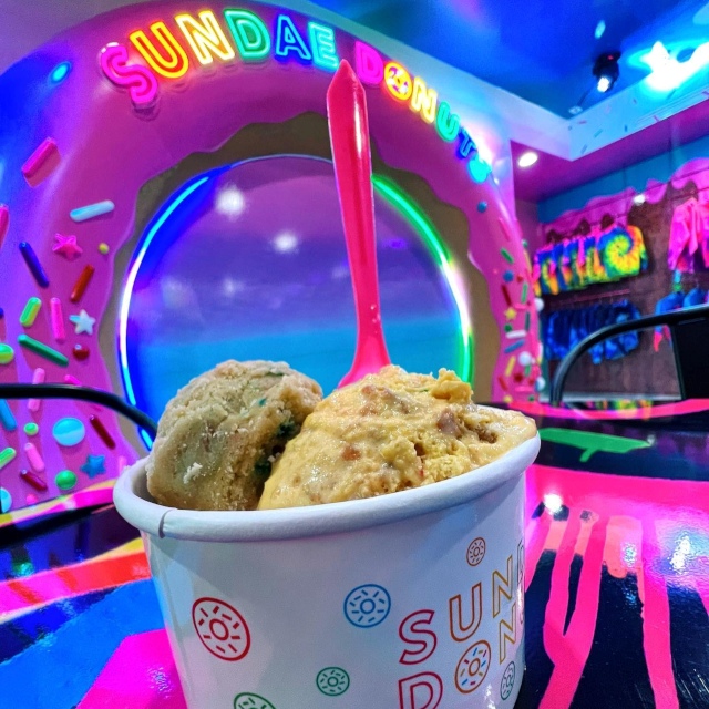 Custom Neon® colorful sign @sundaedonuts with an ice cream cup in the foreground