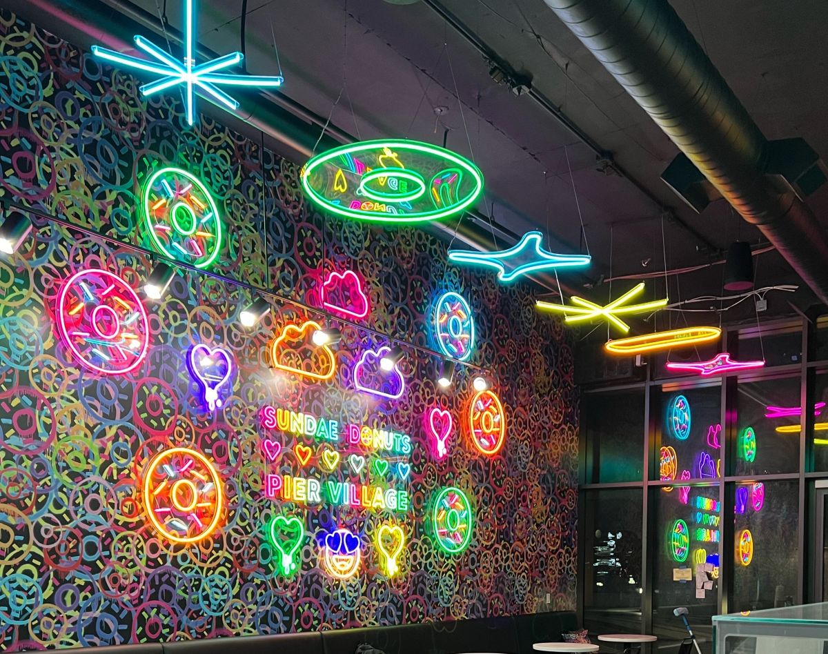 Custom Neon® wall art and suspended neon art hanging over a donut shop interior @sundaedonutspiervillage