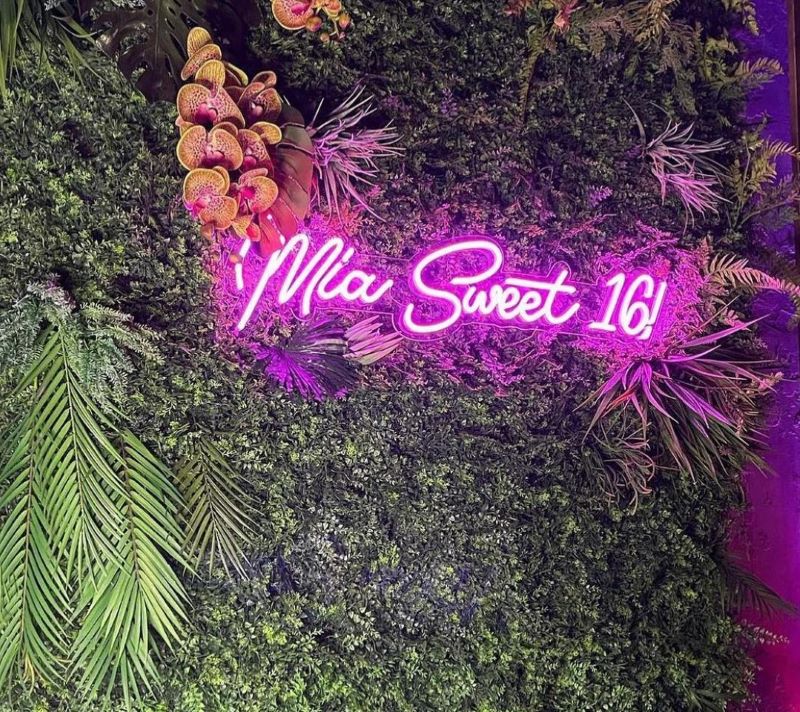 Custom Neon® dark pink Sweet 16 party sign on greenwall @floraloasis.nyc