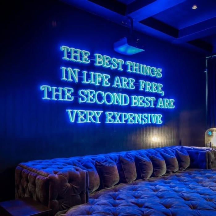The best things in life are free the second best are very expensive Custom Neon® large wall sign in blue LED neon in a room designed by @morroneinteriors